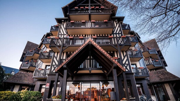 A multi-story building with balconies and a central entrance.