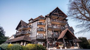 A multi-story building with a traditional architectural style, featuring balconies and a central entrance.