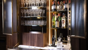 A bar area with shelves of wine bottles and glasses. - Maison 46 (Paris)