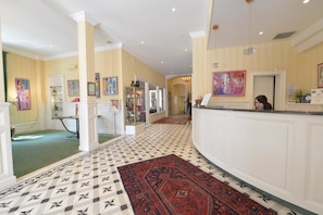 Check-in and unwind in our stylish lobby, featuring a reception desk, seating area, and beautiful artwork.