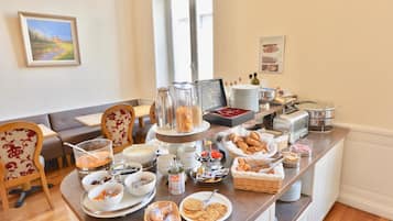 A breakfast buffet with various food items, a coffee station, and seating arrangements.