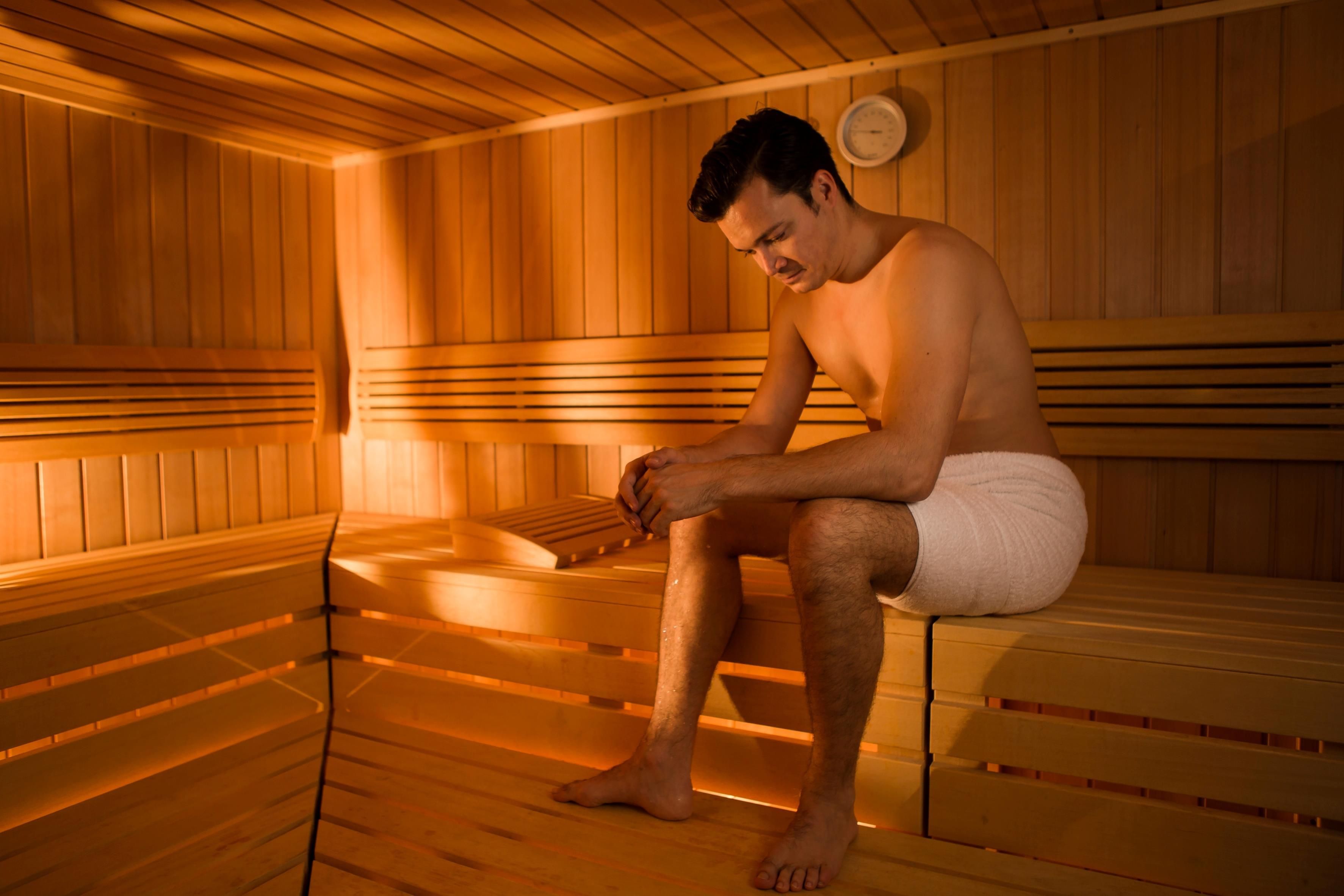 Una sauna con panche in legno e un termometro a parete.