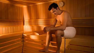 Una sauna con panche in legno e un termometro a parete.