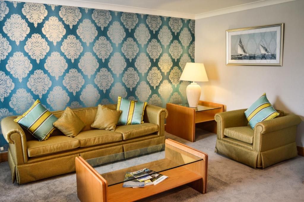A living room with a sofa set, a coffee table, and a lamp.
