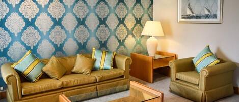 A living room with a sofa set, a coffee table, and a lamp.