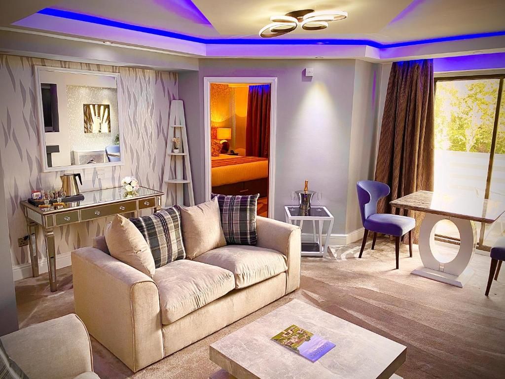 A modern living room with a sofa, coffee table, and a dining area with a table and chairs.