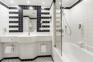 A modern bathroom with a white sink, mirror, and bathtub.