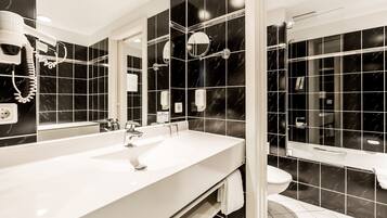 Un baño moderno con un lavamanos grande de color blanco, un espejo y una zona de ducha.