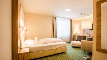 Ein Hotelzimmer mit Bett, Schreibtisch, Stuhl und Lampe.