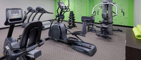 A gym with treadmills, elliptical machines, and weight equipment.