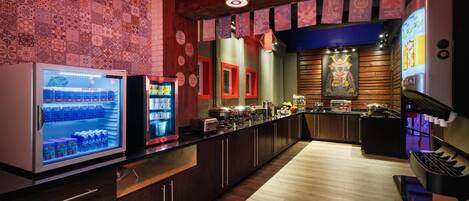 Una cocina moderna con refrigerador, microondas y estufa. Cuenta con gabinetes de madera y salpicadero de azulejos.