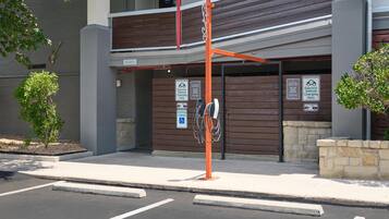 A building with a parking area, electric vehicle charging station, and a sign indicating reserved parking for disabled individuals.