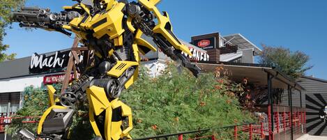 A yellow robot statue in front of a building with a sign that reads "Machi".