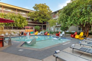 Una piscina al aire libre, tumbonas