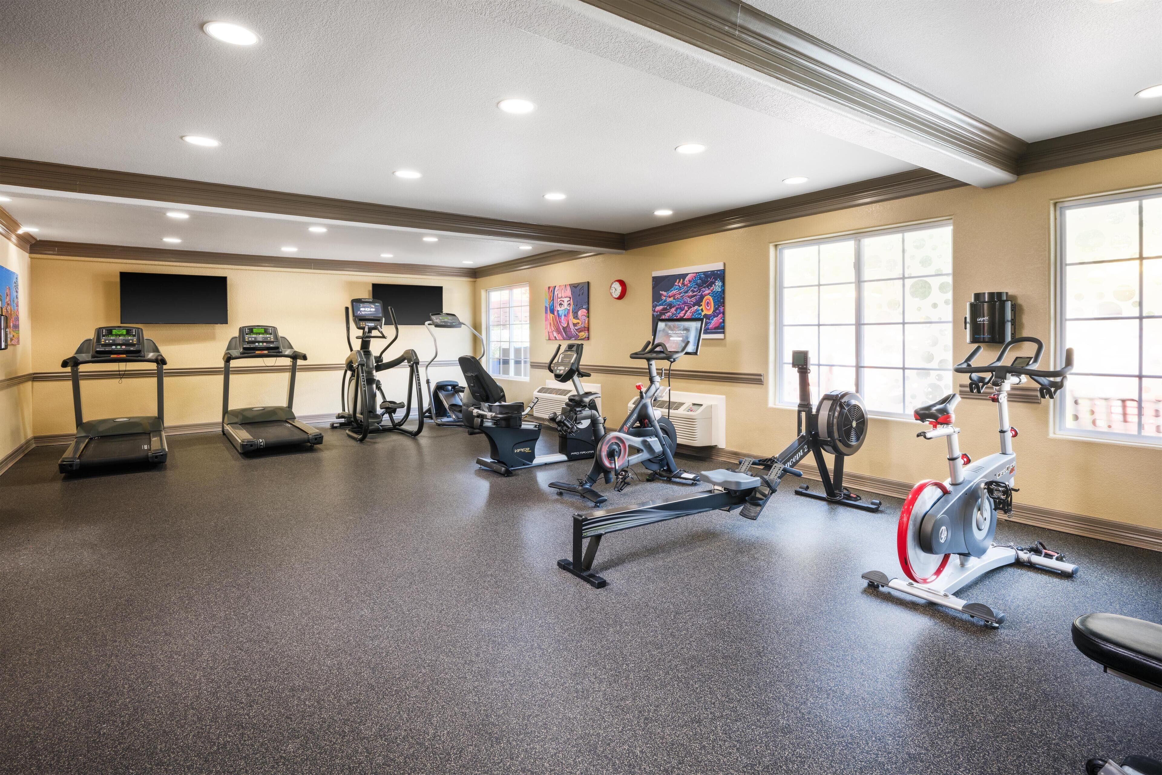 A gym with treadmills, stationary bikes, and elliptical machines.