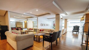 A spacious living room with a sofa, armchairs, and a coffee table. - Loi Flats Buenos Aires (Buenos Aires)