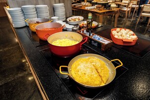 A buffet setup with various dishes and cooking stations.
