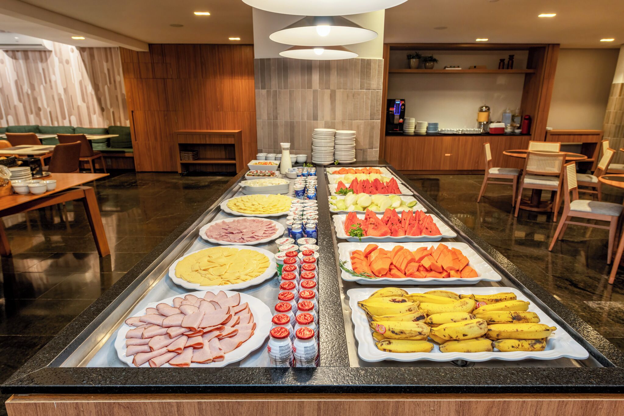 A buffet with various food items including meats, fruits, and beverages.