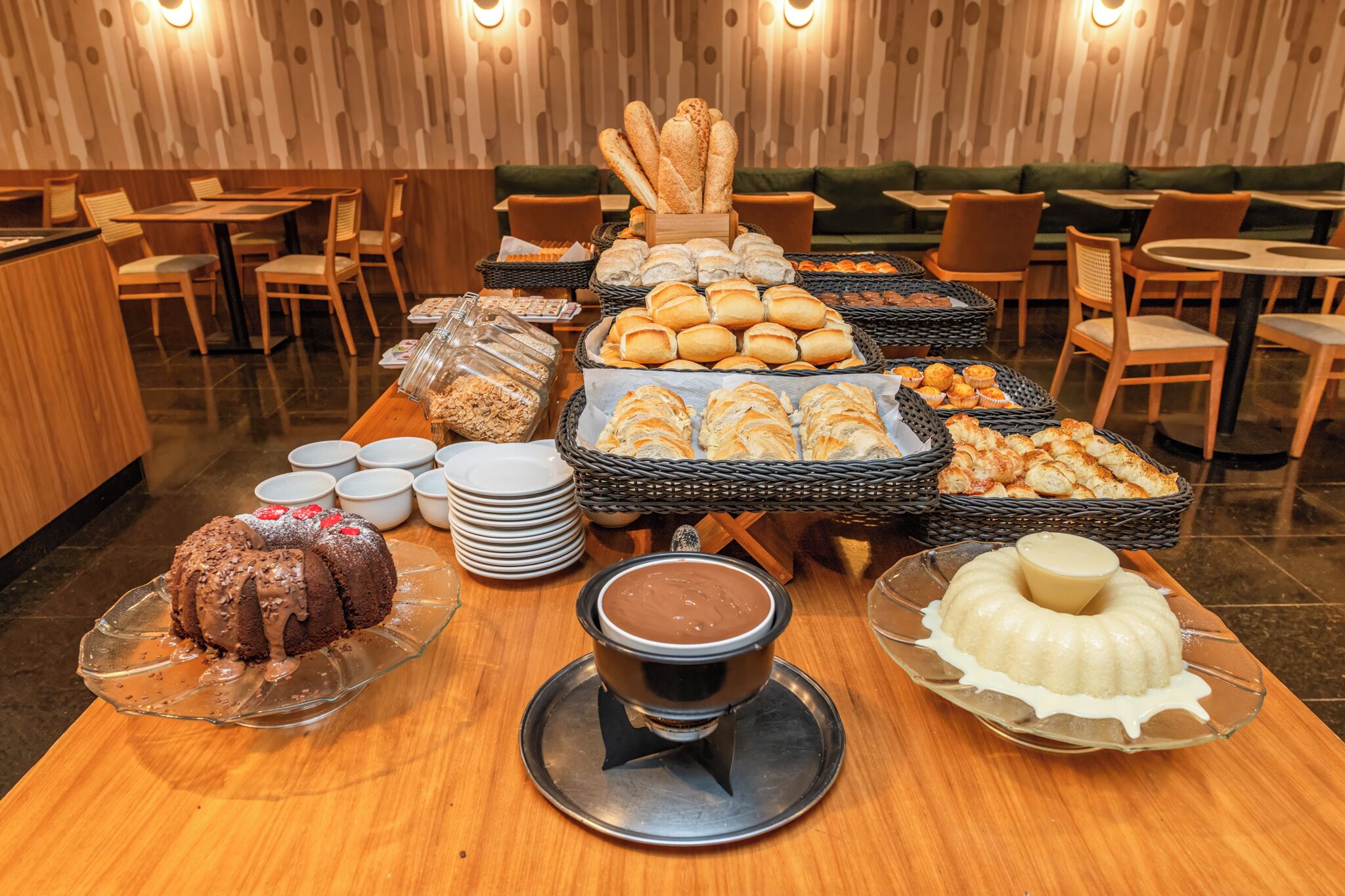 A buffet with various baked goods, a chocolate cake, and a bundt cake.