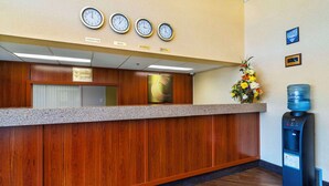 A reception desk with clocks displaying Vancouver, Local, Montreal, and Baxtax times. - Comfort Inn & Suites (Moose Jaw)