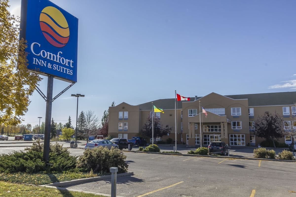 Een Comfort Inn & Suites hotel met een parkeerplaats en een gebouw met meerdere vlaggen.