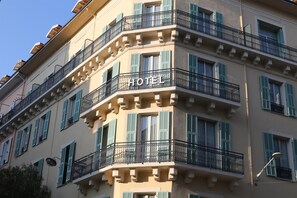Un hôtel à plusieurs étages doté de balcons, une enseigne indiquant qu’il s’agit d’un hôtel et un ciel dégagé.
