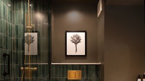 Ein modernes Badezimmer mit einer gläsernen Dusche, einer Toilette und einem Waschbecken mit Handtuchhalter.