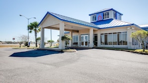 A hotel with a covered entrance, large windows, and a prominent '6' sign on the roof. - Motel 6 Jennings, LA (Jennings)