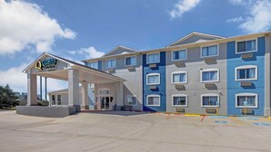 A hotel with a covered entrance, multiple windows, and a clear sky. - Quality Inn El Reno (El Reno)