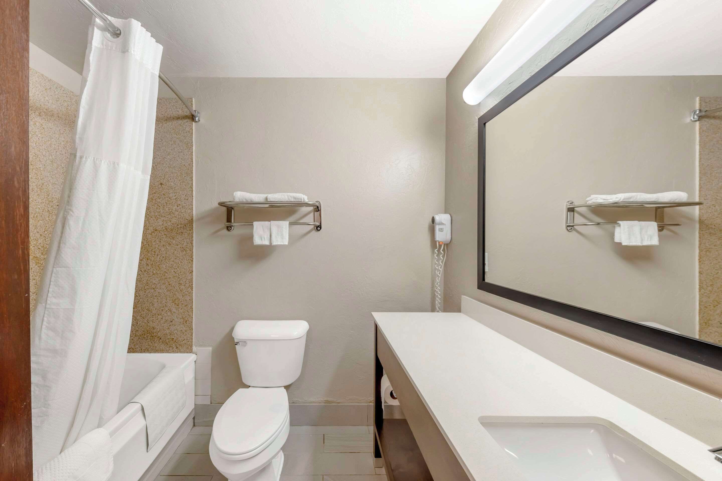 A modern bathroom with a toilet, sink, and shower area.