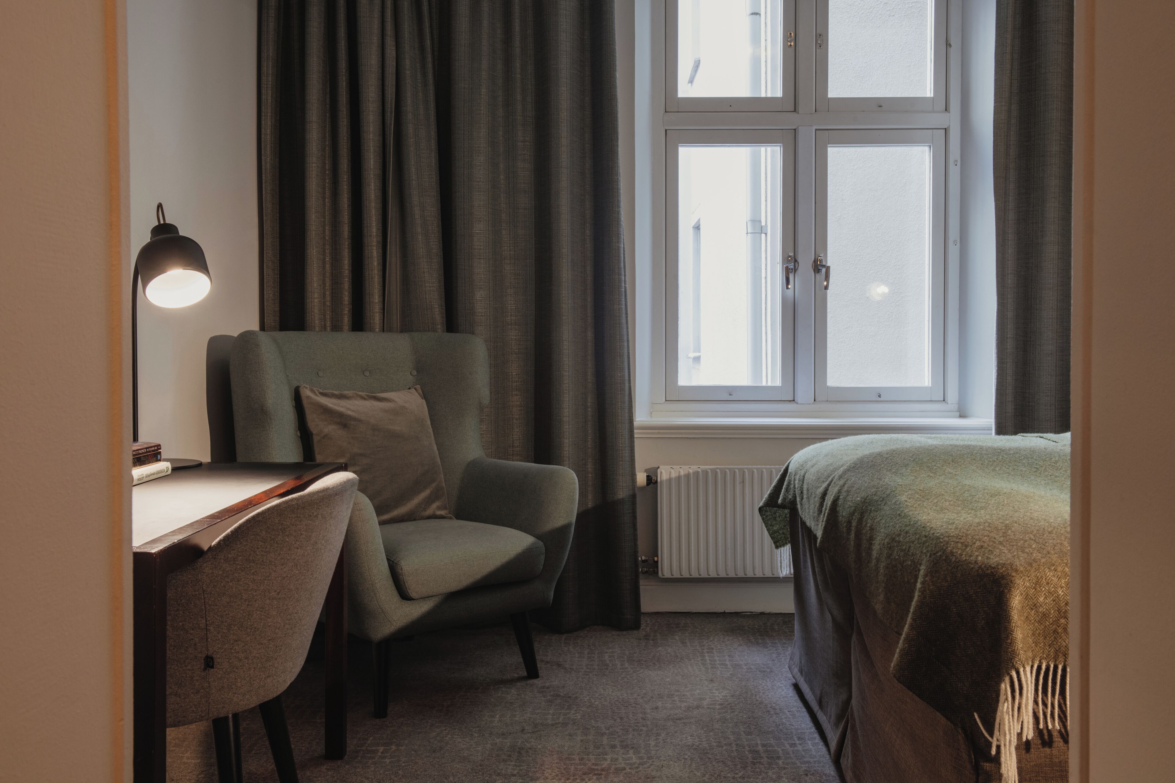 A room with a desk, chair, and a bed.