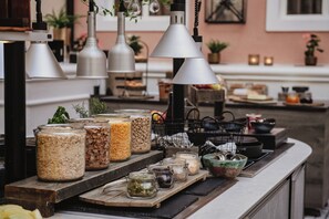 A kitchen counter with various food containers, hanging kitchen lights, and a window in the background.