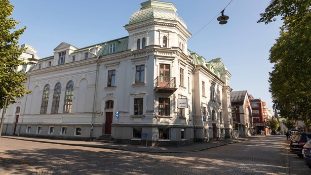A historic building with a prominent dome and classical architecture, situated on a cobblestone street.