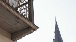 A sign for the Victoria Home Hotel with a view of a church steeple in the background.