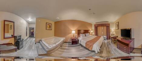 A panoramic view of a hotel room with a curved bed, a television, a desk, and a bathroom with a shower and toilet.