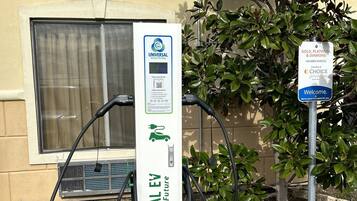 A Universal EV charging station with a sign indicating member parking privileges.