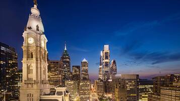 A cityscape with a prominent clock tower and modern skyscrapers.