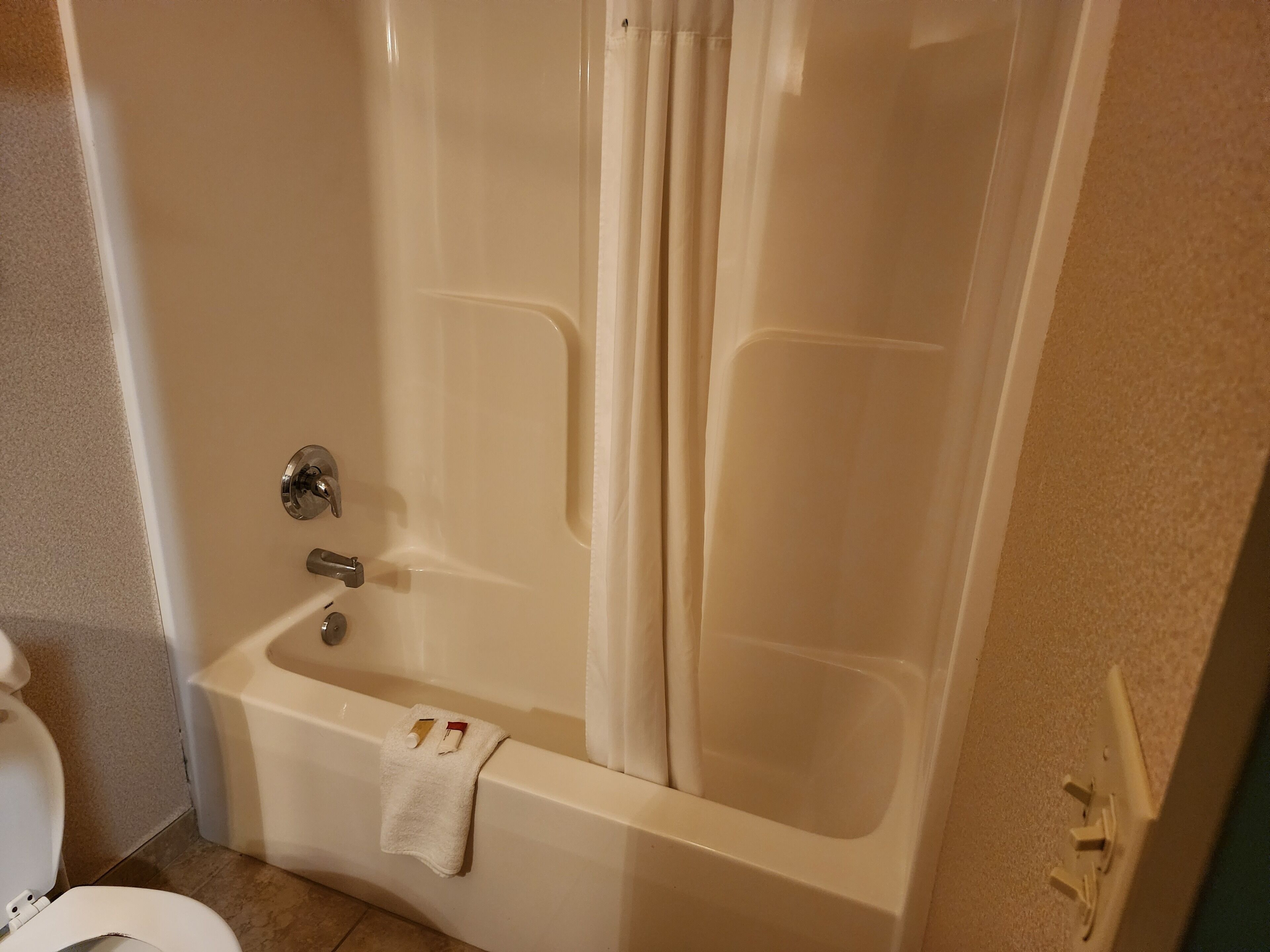 A bathroom with a bathtub, toilet, and a towel rack.