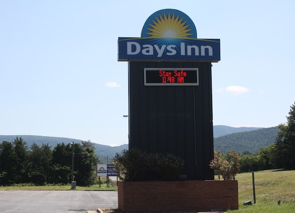 A Days Inn sign with a digital display stating 'Stay Safe 11:48 AM'.