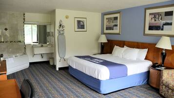 A hotel room with a bed, a desk, a chair, a mirror, a vanity, and a window.