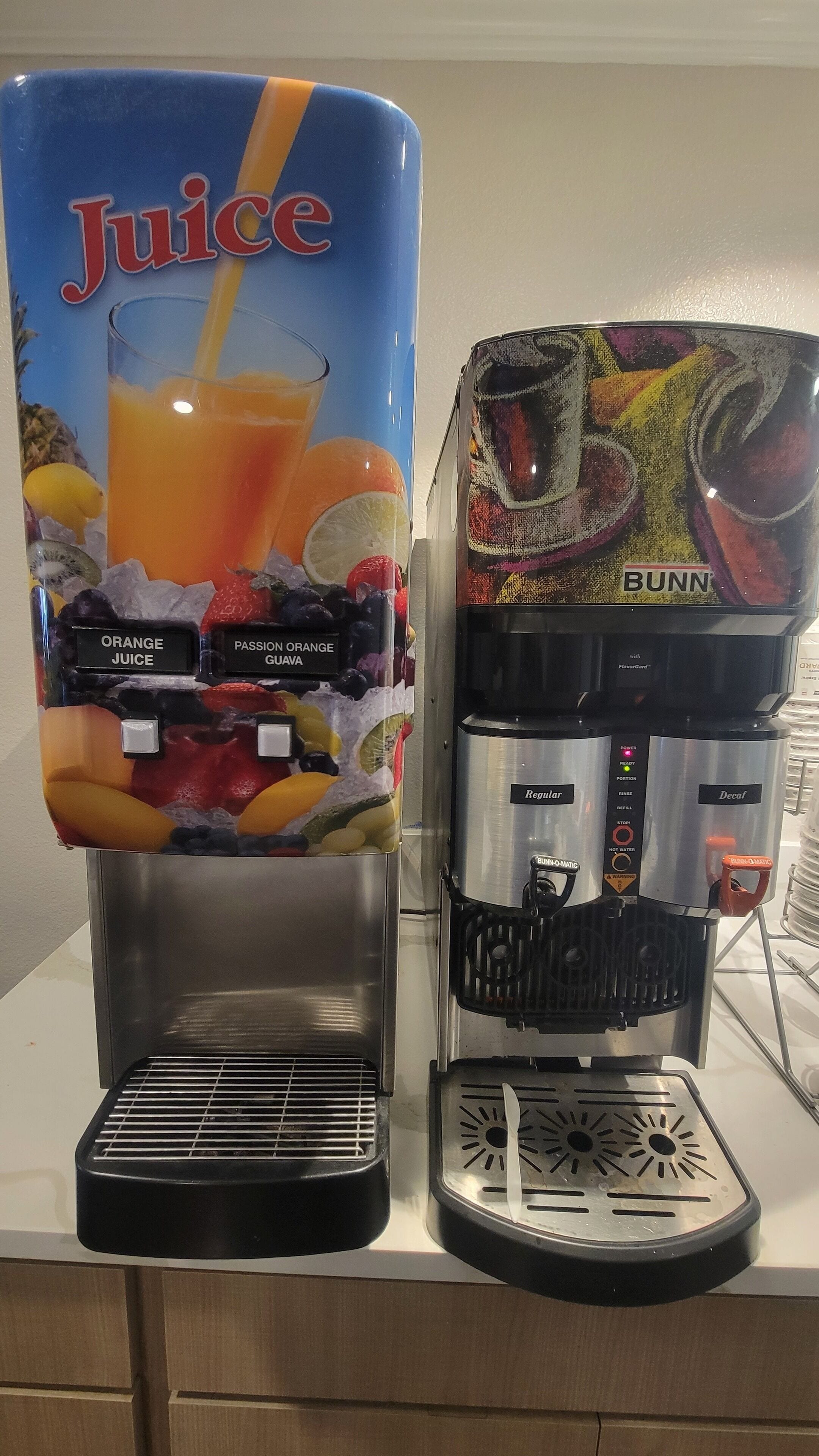 Een sapdispenser en een koffieapparaat staan naast elkaar.