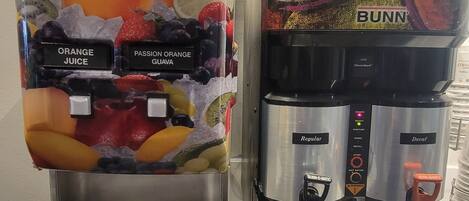 Een sapdispenser en een koffieapparaat staan naast elkaar.