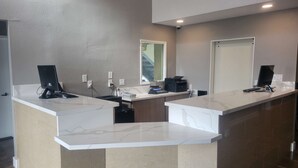 A reception desk with two computer monitors, a printer, and a phone. - SureStay Hotel by Best Western Chula Vista San Diego Bay (Chula Vista)