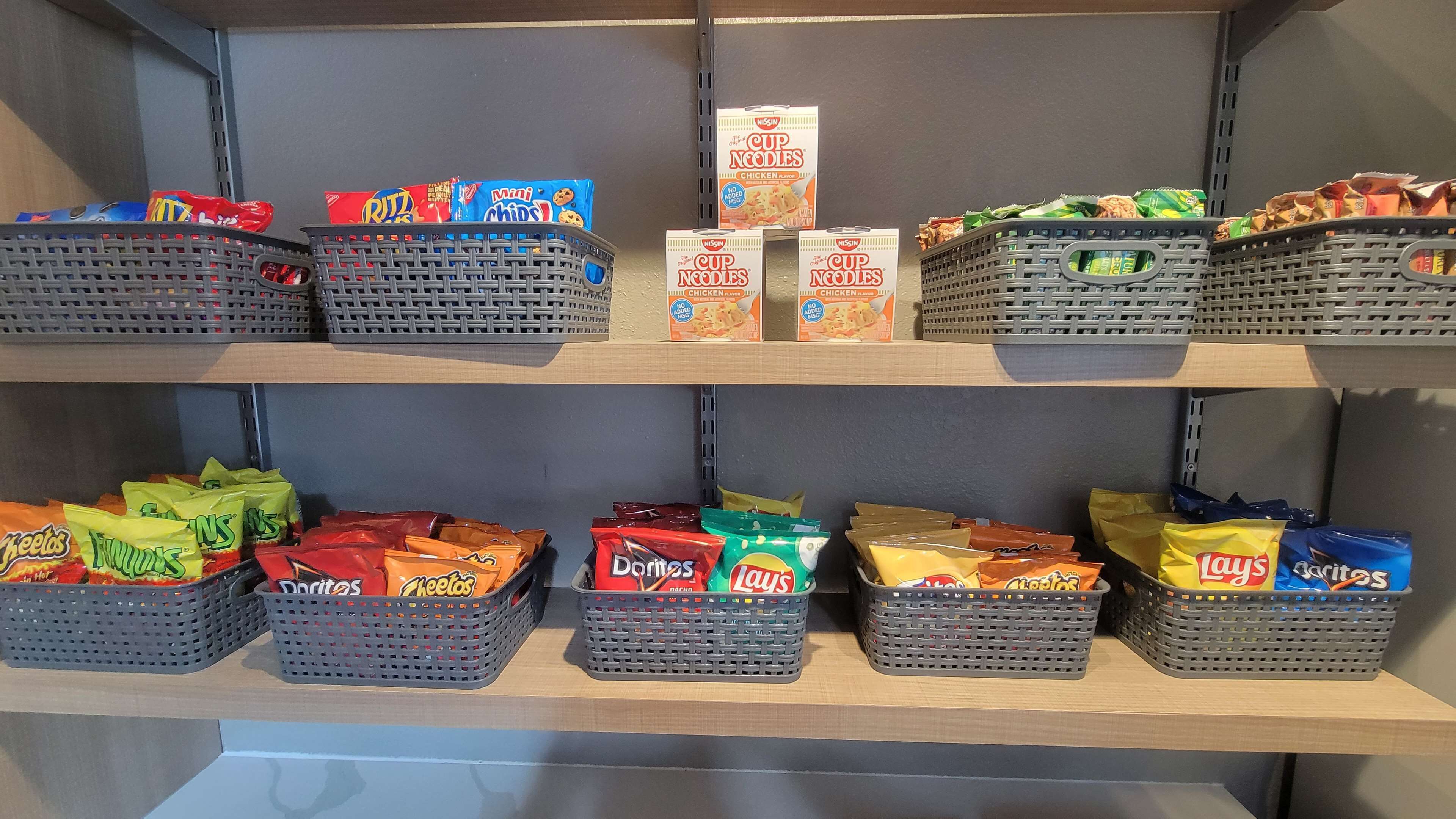 A snack display with various brands like Ritz, Mini Chips, Doritos, and Lay's.