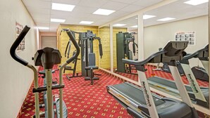 Ein Fitnessstudio mit Laufbändern, Crosstrainern und Gewichten.