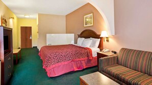 Ein Hotelzimmer mit Bett, Sofa, Schreibtisch und Fernseher.