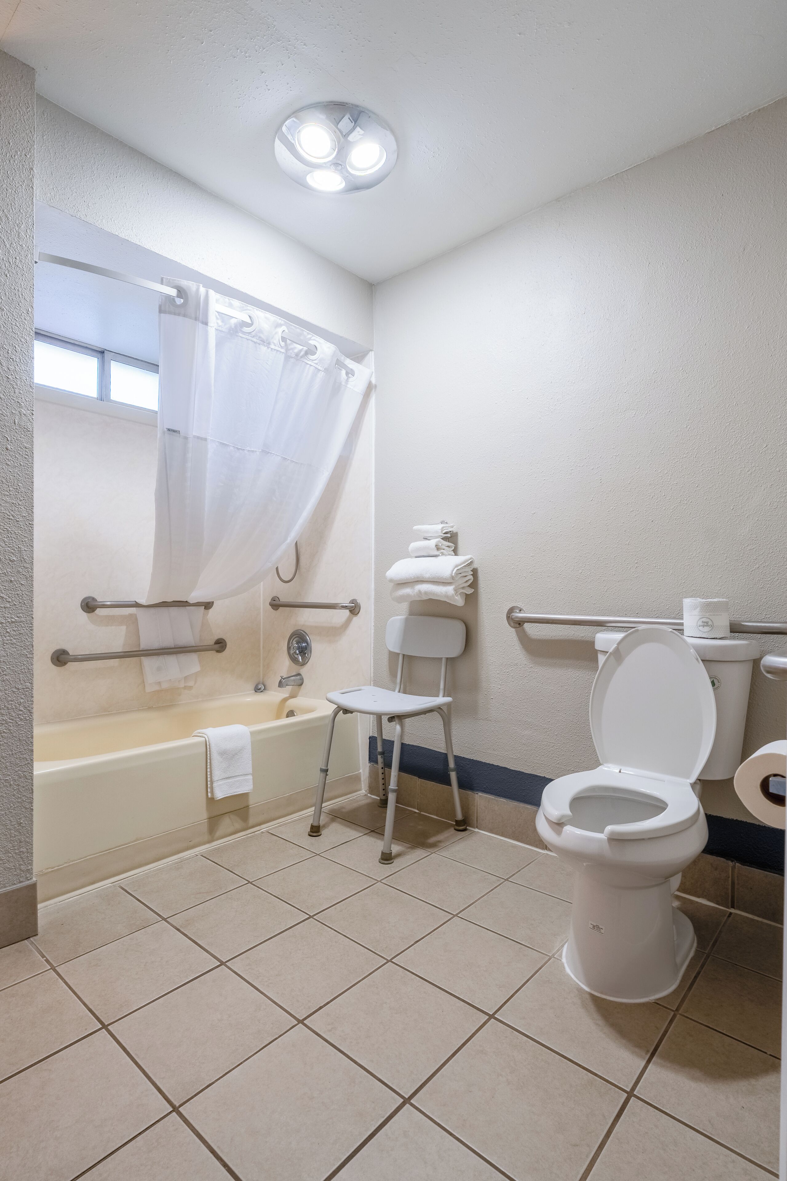 A bathroom with a bathtub, toilet, and a shower area.