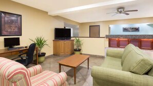 A living room with a television, computer, and two couches.
