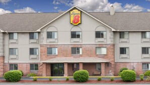A Super 8 hotel with a brick facade, multiple windows, and a clear sky.