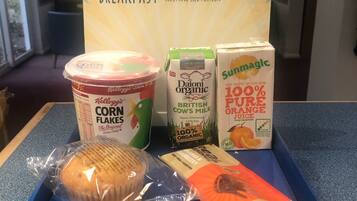 Una caja de desayuno con un precio de £5.50, que contiene cereal Kellogg’s, leche orgánica y un muffin.